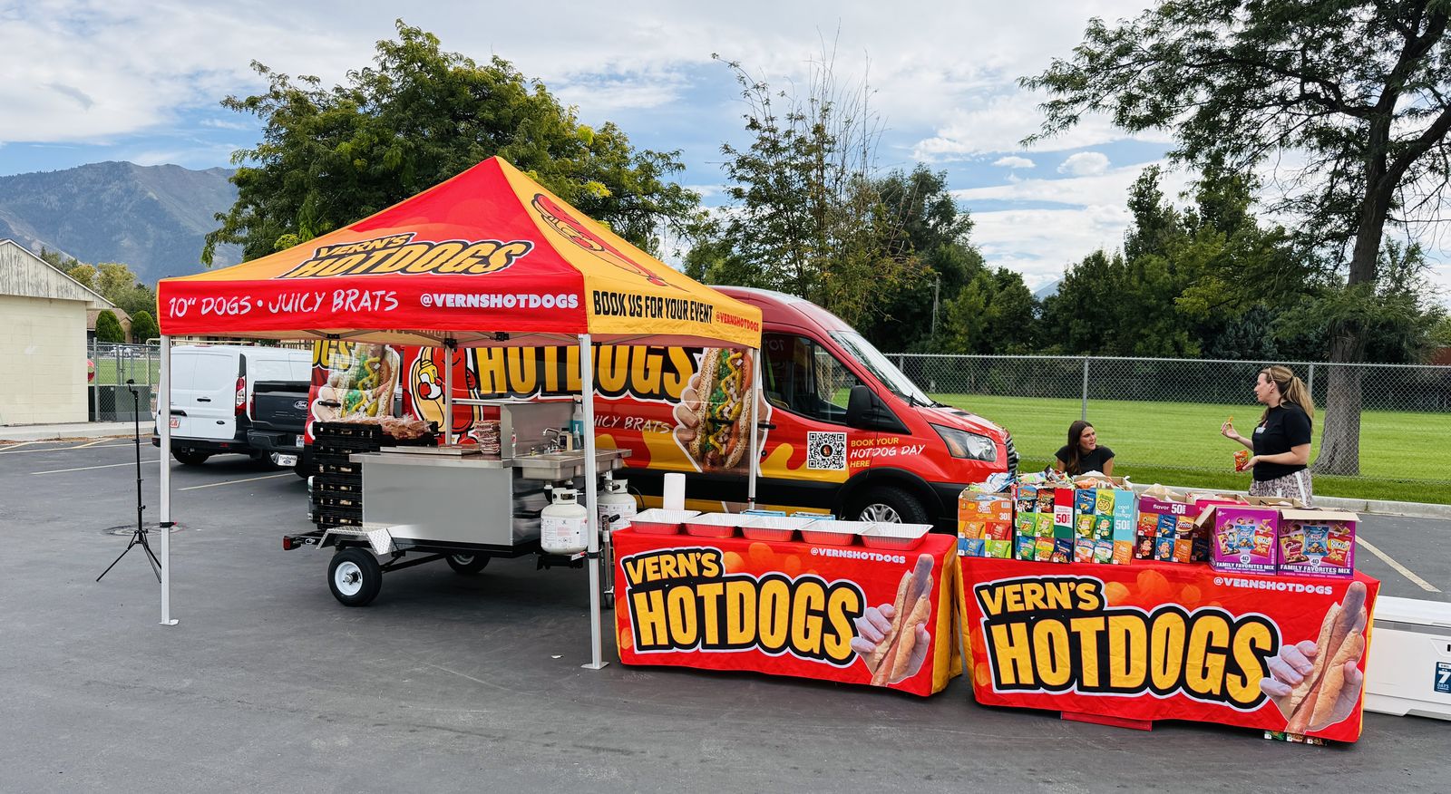 Vern's Hot Dogs branded cart, canopy, and table covers set up at an event